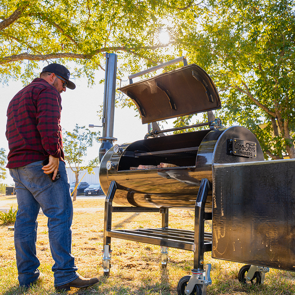 Cook checking out steaks on a backyard smoker in Texas. 
