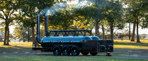 Texas made, custom triple-axle trailer featuring dual 1000-gallon offset smokers with NSF-certified tanks and insulated fireboxes, handcrafted for high-volume commercial BBQ.